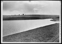 Completed stock water dam which will benefit ranch in background. Pennington County, South Dakota. Sourced from the Library of Congress.