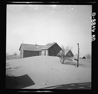 Dust piled up around farmhouse. Oklahoma. Sourced from the Library of Congress.