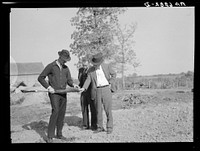The Farm Security Administration supervisor shows the creditor the type of soil on the farm of the Farm Security Administration client. The rehabilitation supervisor stands by. Monroe County, Iowa. Sourced from the Library of Congress.