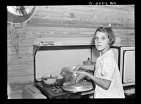 While father and mother are both at work in the citrus packing plant this little girl keeps house. Winterhaven, Florida. Sourced from the Library of Congress.