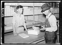 Buying shoes in the cooperative store at Irwinville Farms, Georgia. Sourced from the Library of Congress.