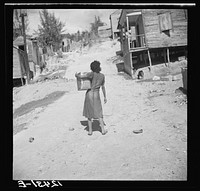 Girl carrying water in gasoline can. Ponce, Puerto Rico. Sourced from the Library of Congress.