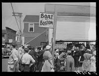 Tourist, fresh off the boat from Boston. With only two hours in town, they buy seashells, dinners, trinkets and rides on the sightseeing bus. Provincetown, Massachusetts. Sourced from the Library of Congress.