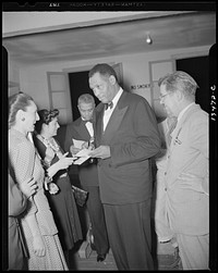 Washington, D.C. Russian war anniversary benefit at the Watergate. Paul Robeson and autograph hunters backstage. Sourced from the Library of Congress.