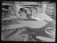 New York, New York. Preparing the defense bond sales photomural, designed by the Farm Security Administration, to be installed in the Grand Central terminal, in the shop of a contractor. Cutting out part of a large figure mounted on homosote board with a routing machine. Sourced from the Library of Congress.