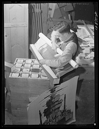 Washington, D.C. Preparing the defense bond sales photomural, to be installed in the Grand Central terminal, New York, in the visual unit of the Farm Security Administration. Packing finished print strips for one unit, keyed by code according to the dummy, for future assembly. Sourced from the Library of Congress.