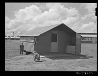 Children playing in front of house. Tulare migrant camp. Visalia, California. Sourced from the Library of Congress.