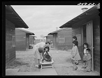 [Untitled photo, possibly related to: Harlingen, Texas. FSA (Farm Security Administration) camp. Nurse taking a boy with a fractured leg out for air]. Sourced from the Library of Congress.