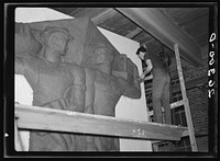 Washington, D.C. Vernon Atchely of the Special Skills division of the U.S. Resettlement Administration working on figures modeled in relief for the Greendale school. Sourced from the Library of Congress.