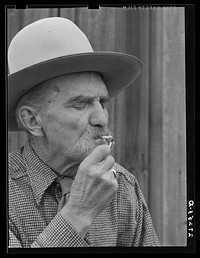 Frank Latta lighting a hand-rolled cigarette. Bozeman, Montana. Sourced from the Library of Congress.