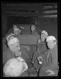 Underground at Old Ben number eight mine. These men are on a "man-trip" which goes three and half miles to the face of the coal. General caption: Most of the giant coal producers in Franklin Couny have completely mechanized underground operations. Old Ben number eight, because of shortage of working capital, has not been able to install loading machines to handle the entire output of the mine. Accordingly, the mine still uses the now obsolete pit car loader, and even employs a few hand loaders alongside modern, highly efficient automatic loading machines. Sourced from the Library of Congress.