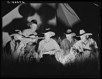 [Untitled photo, possibly related to: Cowhands singing after day's work. Quarter Circle 'U' Ranch roundup. Big Horn County, Montana]. Sourced from the Library of Congress.