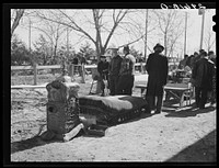 [Untitled photo, possibly related to: Neighbors examine furniture to be auctioned at P.C. Zimmerman's farm near Hastings, Nebraska]. Sourced from the Library of Congress.