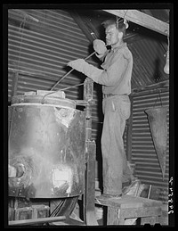 Stirring molten gold and silver in furnace. El Dorado Canyon, Nevada. Sourced from the Library of Congress.