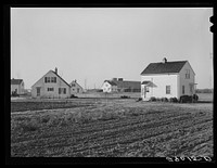 Group of homes located near the dairy farms on Bois d'Arc Cooperative farm. The same well and pump that furnishes water for the barns serves to supply the homes. Osage Farms, Missouri. Sourced from the Library of Congress.