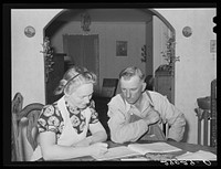 Mr. and Mrs. Fred Maschman going over their record book discuss ways of making their new farm, purchased with FSA (Farm Security Administration) aid, more profitable. Iowa County, Iowa. Sourced from the Library of Congress.