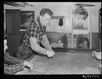 Farmer and townspeople have more leisure time to play cards in pool room during winter months. Woodstock, Vermont. Sourced from the Library of Congress.