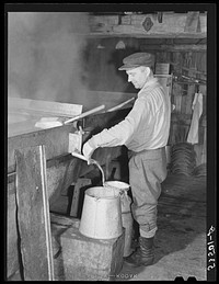 Walter M. Gaylord syruping off the maple sap has finally boiled down in the King evaporator to the correct syrup consistancy. He averages about 150 gallons annually, but this year tapped only 600 of his 1000 trees because of unusually deep snow and late spring. He owns several farms; in this particular unit there are eighty acres. It has been in his family for three generations. He has about forty head of cattle, raises poultry and potatoes. Sourced from the Library of Congress.