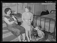 Home management supervisor Mrs. Merrin discusses the canning program with one of camp members inside her shelter. Osceola migratory labor camp. Belle Glade, Florida. Sourced from the Library of Congress.