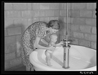 Showers for both babies and older children and parents and complete laundry facilities are provided in the utility building for members of the Osceola migratory labor camp. Belle Glade, Florida. Sourced from the Library of Congress.