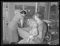 Showers for both babies and older children and parents and complete laundry facilities are provided in the utility building for members of the Osceola migratory labor camp. Belle Glade, Florida. Sourced from the Library of Congress.
