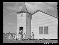 [Untitled photo, possibly related to: The women's club leaving the church and community building after a home management demonstration by the supervisor and a baby shower they gave for Mrs. Verden Lee, one of their members. Transylvania Project, Louisiana]. Sourced from the Library of Congress.