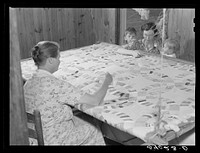 Mrs. Clarence N. Pace with her children and her mother-in-law quilting in their home. Transylvania Project, Louisiana. Sourced from the Library of Congress.