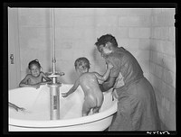Showers for both babies and older children and parents and complete laundry facilities are provided in the utility building for members of the Okeechobee migratory labor camp. Belle Glade, Florida. Sourced from the Library of Congress.