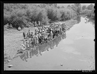 [Untitled photo, possibly related to: Members of the Primitive Baptist Church in Morehead, Kentucky, attending a creek baptizing by submersion]. Sourced from the Library of Congress.