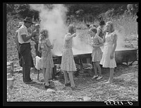In the early fall many of the children remain away from school on "syrupping off" days. Sorghum syrup is boiled down from the cane sap by one of the men from the neighborhood who does this work for different members of the communities, taking a share of the syrup for his labor. On the highway between Campton and Jackson, Kentucky. Sourced from the Library of Congress.