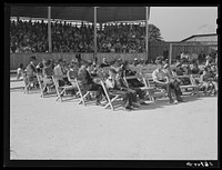 Listening to the school superintendent and Governor Hoey speak at the Caswell County Fair. Yanceyville, North Carolina. Sourced from the Library of Congress.