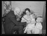 [Untitled photo, possibly related to: Dr. S.A. Malloy examining Mrs. William H. Willis and her family. Mr. Willis is a FSA (Farm Security Administration) borrower. Blanch, Caswell County, North Carolina]. Sourced from the Library of Congress.
