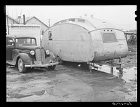 Trailer and car belonging to Paul Knight, construction worker at Fort Benning building new barracks. He pays two dollars for trailer space (only) in W.T. Willis' backyard, is from Stone Mountain, Atlanta, Georgia. He said the bad roads were one of the worst problems around there and agreed that things generally were bad and the government had better do something about it soon. Sourced from the Library of Congress.