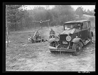 [Untitled photo, possibly related to: Close-up of car from Mississippi used for sleeping as well as shelter and traveling. Evidences of cooking outdoors are beside it. On highway near Camp Livingston, Alexandria, Louisiana]. Sourced from the Library of Congress.