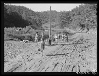 Going home from school in Breathitt County, Kentucky. The school year begins in July and ends in January, as most of the children have no shoes and insufficient clothing to walk the long distances over bad roads and up creek beds. Sourced from the Library of Congress.