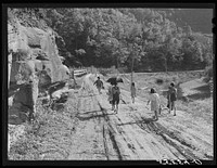Going home from school iIn Breathitt County, Kentucky. The school year begins in July and ends in January, as most of the children have no shoes and insufficient clothing to walk the long distance over bad roads and up creek beds. Sourced from the Library of Congress.