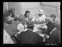 Migratory laborers and vegetable pickers playing "skin" game in back of juke joint and bar in the Belle Glade area of south central Florida. Sourced from the Library of Congress.