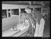 Major Cooke and Mr. O.E. Miller, personnel director for the construction company, inspecting beds inside barracks where construction workers live at Camp Blanding, Florida. Sourced from the Library of Congress.
