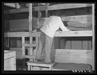 Porter making up beds in barracks. Camp Blanding, Starke, Florida. Sourced from the Library of Congress.