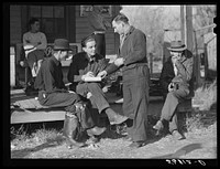 Fur buyer handing FSA (Farm Security Administration) supervisor his bid on the next lot of muskrats. The auction sale is being held on the porch of the community general store in Saint Bernard, Louisiana. Sourced from the Library of Congress.