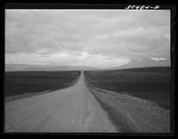 Road to Glacier National Park just after sundown, with storm over the Rocky Mountains in the distance. Montana. Sourced from the Library of Congress.