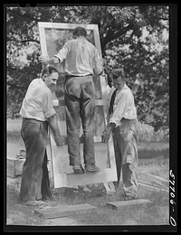 Testing a home-made screen door for strength. Screening demonstration. Charles County, La Plata, Maryland. Sourced from the Library of Congress.