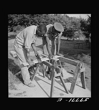Cutting screen door stock to measurement. Screening demonstration. Saint Mary's County, Ridge, Maryland. Sourced from the Library of Congress.