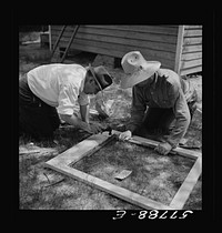 All joints on the outside face are reinforced first. Screen door construction demonstration. Charles County., La Plata, Maryland. Sourced from the Library of Congress.