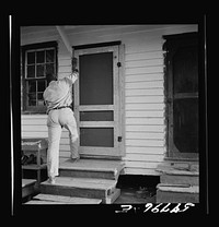 Assembling screen door to door frame. Screening demonstration. Saint Mary's County, Ridge, Maryland. Sourced from the Library of Congress.