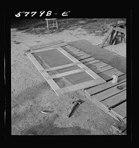 Screen door assembled. The hinge strip, handles, and coil spring remain to be assembled to complete the door. Saint Mary's County, Ridge, Maryland. Screening demonstration. Sourced from the Library of Congress.