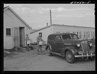 Sam Clover, in charge of poultry department, and his helper bringing in case of eggs out of the poultry house. Eggs are marketed through large cafes, restaurants and eating houses in Omaha. The demand for the co-op's premium eggs is in excess of the supply. Two Rivers Non-Stock Cooperative, Farm Security Administration co-op. Waterloo, Nebraska. Sourced from the Library of Congress.