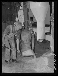 Harvey Renninger, in charge of purchasing and marketing enterprise, grinding feed in the mill. Two Rivers Non-Stock Cooperative, a FSA (Farm Security Administration) co-op. Waterloo, Nebraska. Sourced from the Library of Congress.