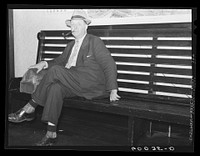 Man waiting for bus in hotel lobby. Elkins, West Virginia. Sourced from the Library of Congress.