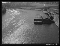 Barges on the river. Minneapolis, Minnesota. The one in the foreground is loaded with wheat for Memphis. Sourced from the Library of Congress.